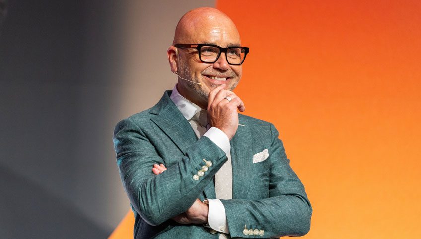 Mannelijke coach in pak staat op het podium