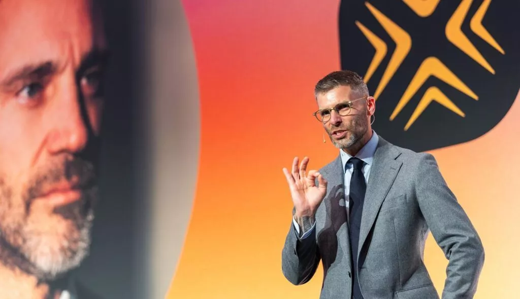 Coach in pak geeft presentatie op podium tijdens Inner Stance event