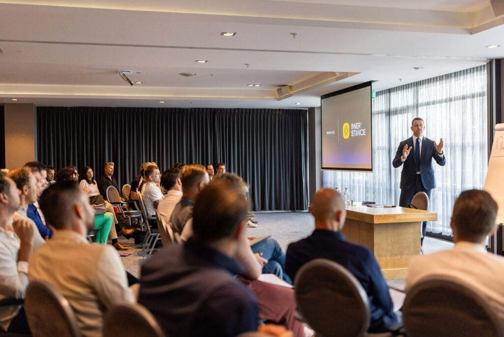 Man geeft presentatie aan publiek tijdens Inner Stance event