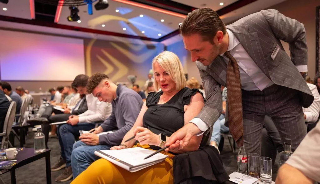 Mannelijke coach geeft deelneemster Inner Stance event uitleg