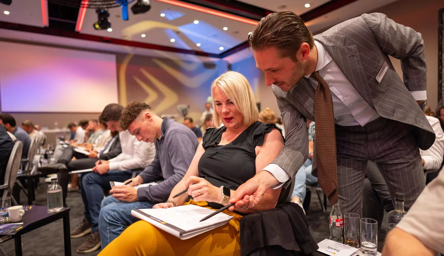 Mannelijke coach geeft deelneemster Inner Stance event uitleg