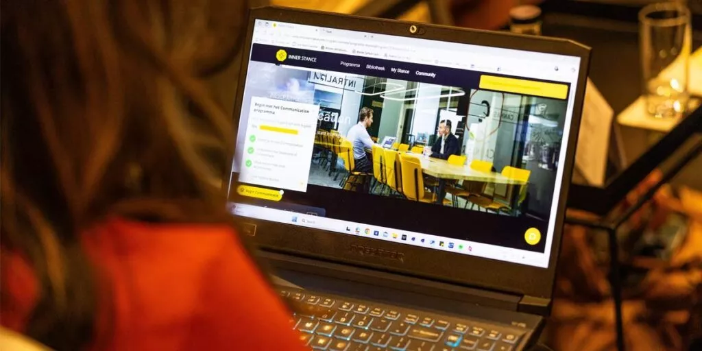 Vrouw bekijkt op laptop naar het online coachingsysteem van Inner Stance